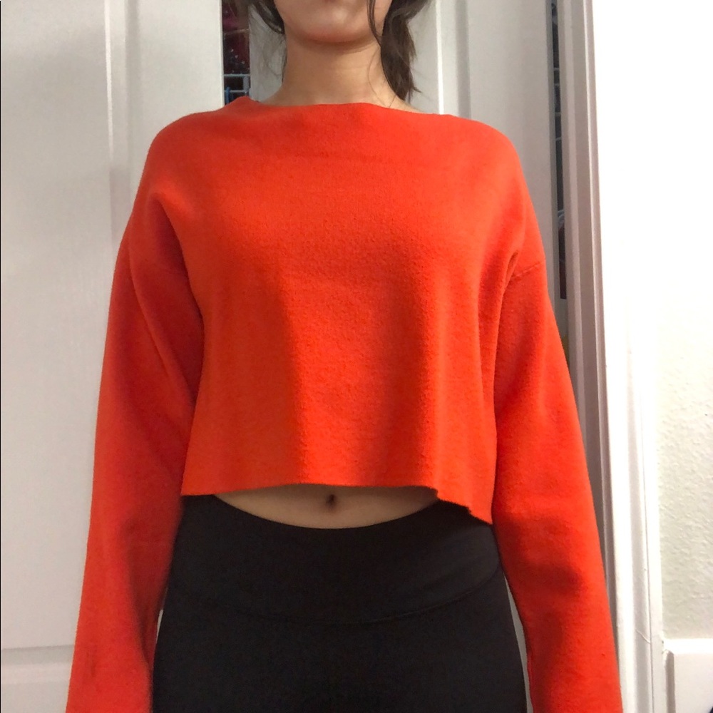 Bright red-orange sweater ties at the back